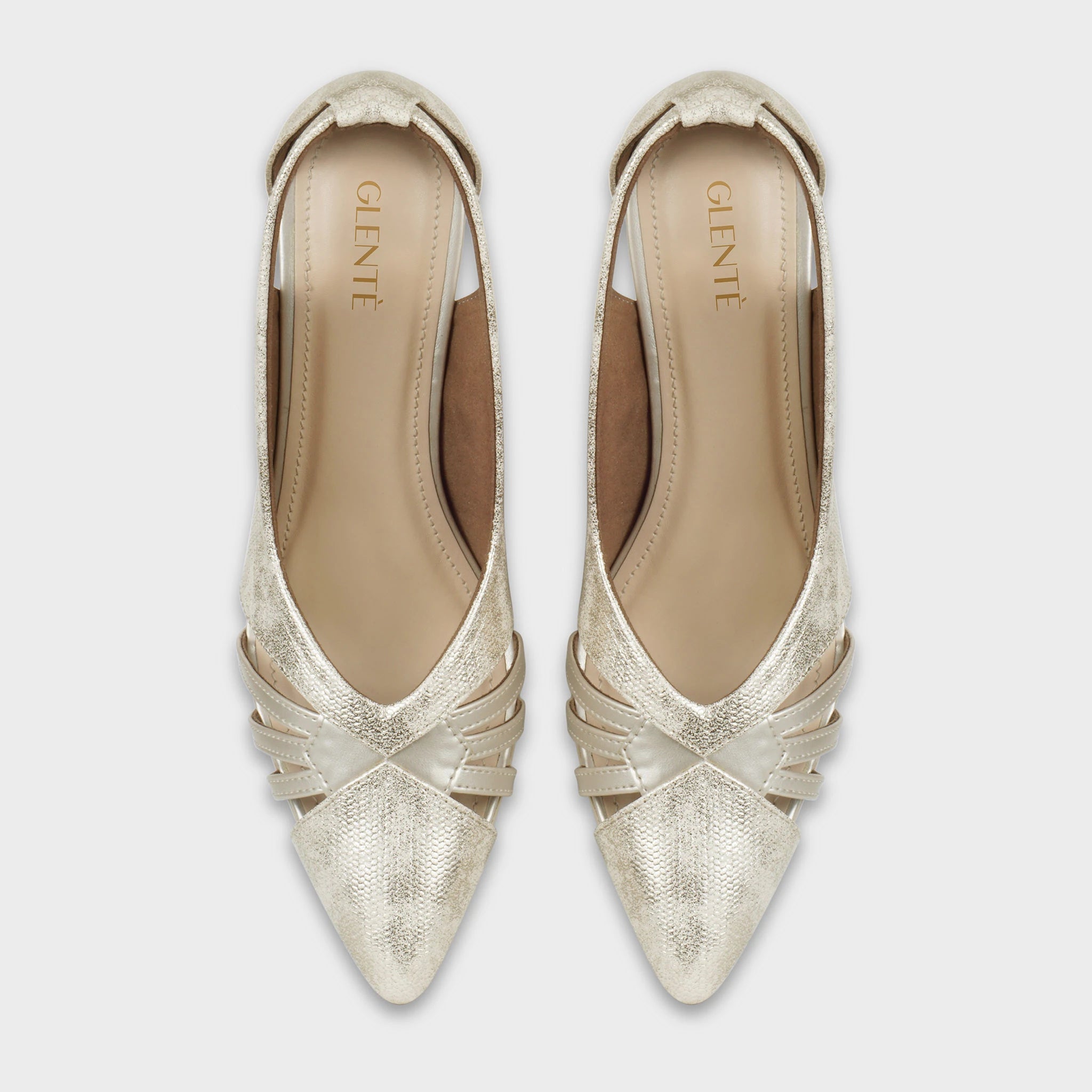 Top-down view of Altavie gold shimmer pointed-toe pumps as a pair, showing the symmetrical cage strap design at the toe, deep side cutouts, and gold Glentè branding on the insoles