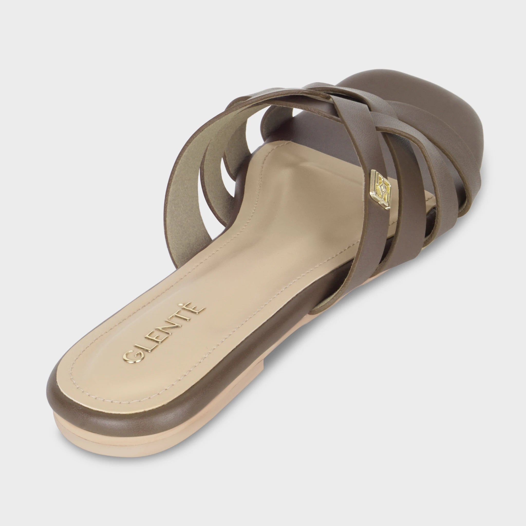Rear angled view of Averis brown flat slides showing the cushioned insole with embossed gold Glentè branding, woven strap architecture, and nude outsole edge