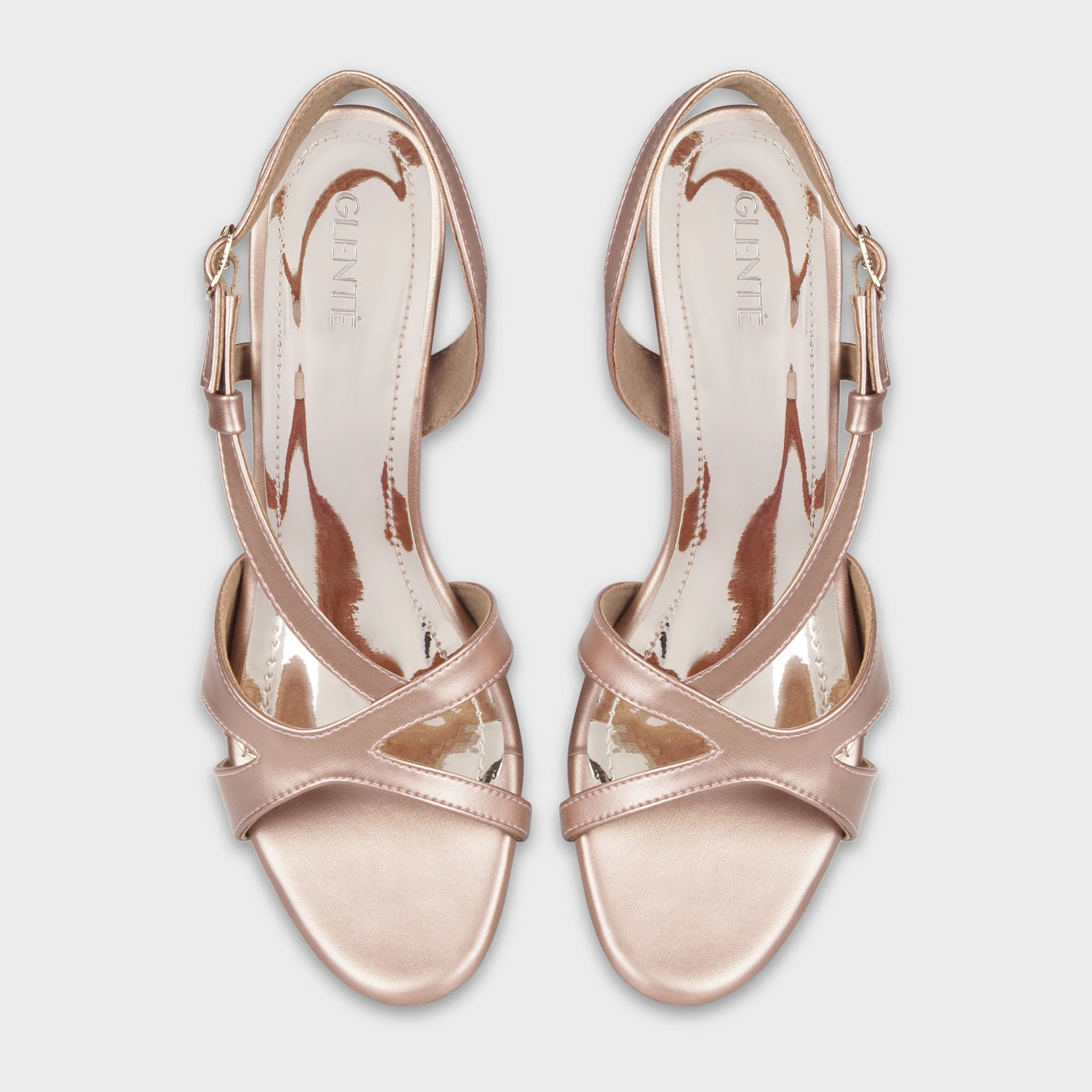 Top-down view of Orisea rose gold slingback heels as a pair, showing the symmetrical crossover strap pattern, embossed Glentè logo on glossy insoles, and adjustable buckle closures