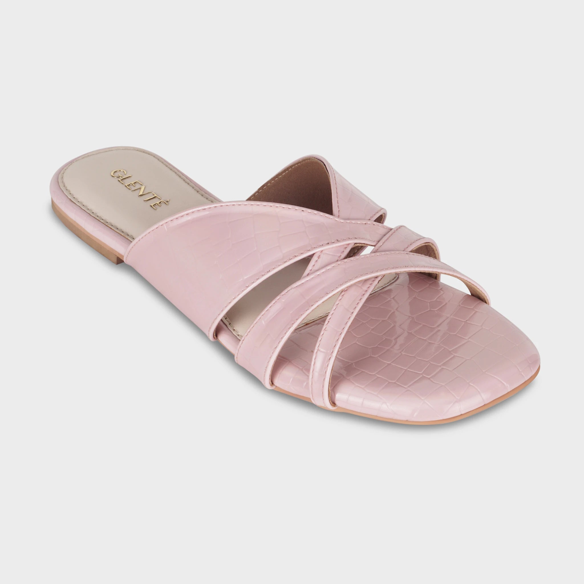 Front angled view of Seraya pink croc-embossed flat slides highlighting the open toe, interwoven strap construction, and gold Glentè logo on the heel pad
