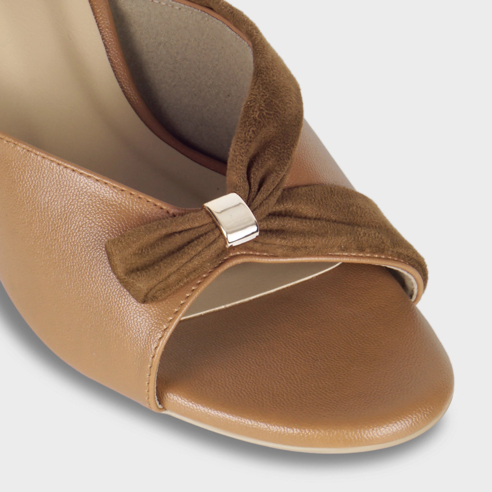 Close-up of the Solviane gathered brown suede knot detail with polished gold rectangular clasp, showing the contrast between smooth tan leather upper and soft suede bow - Glentè