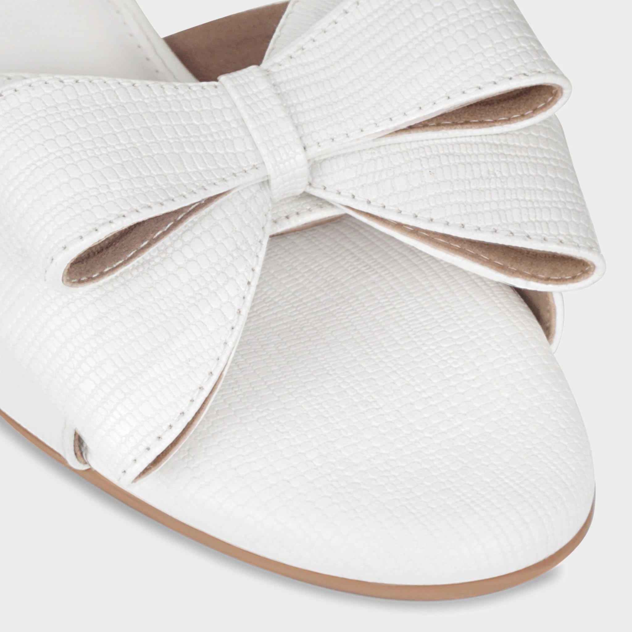 Close-up of the Alveria structured double bow showing the glossy white lizard-emboss pattern, neat center knot construction, and lustrous finish - Glentè
