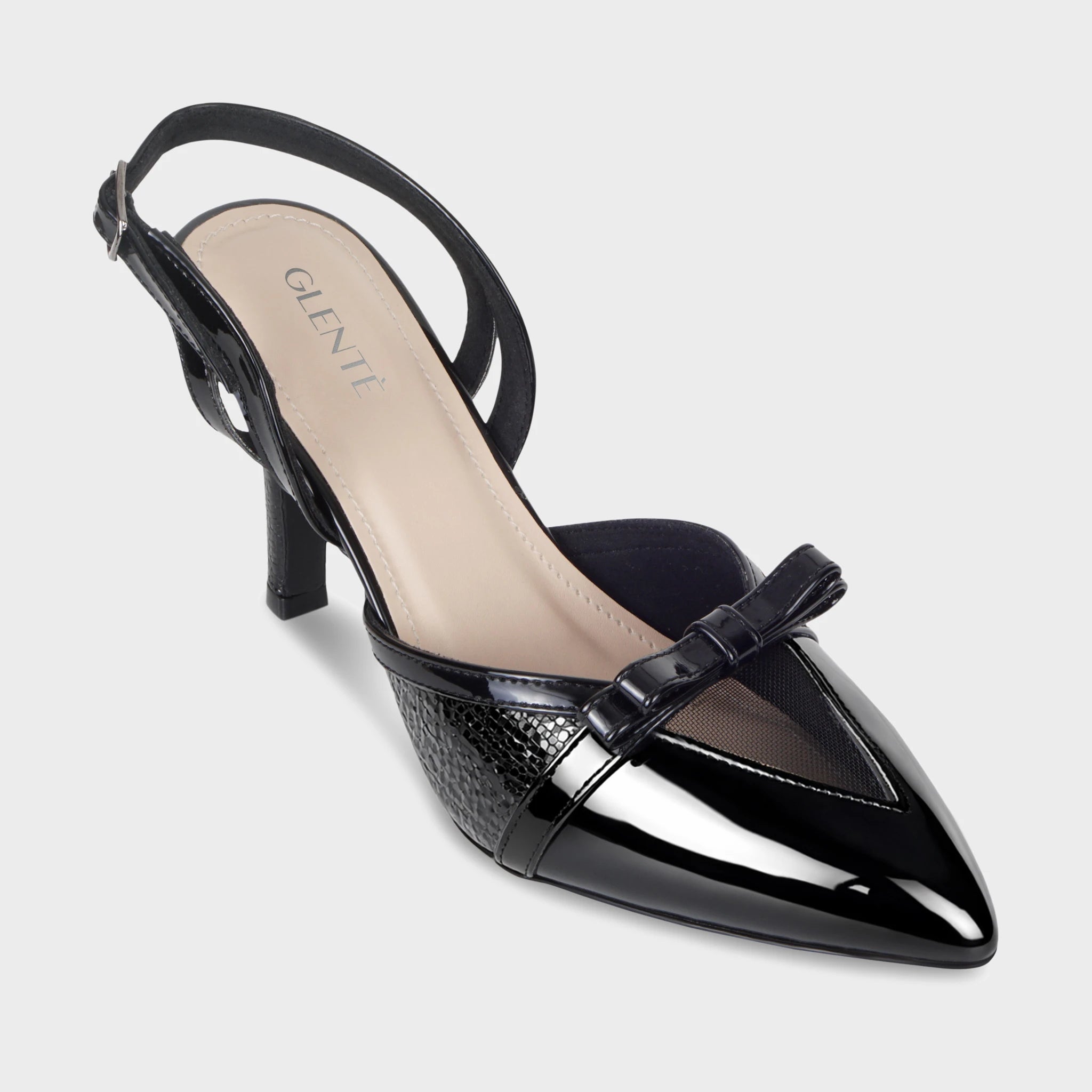Front angled view of Celestrine black patent slingback heels highlighting the pointed toe, sheer mesh V-insert, patent bow detail, and Glentè branding on the cream insole