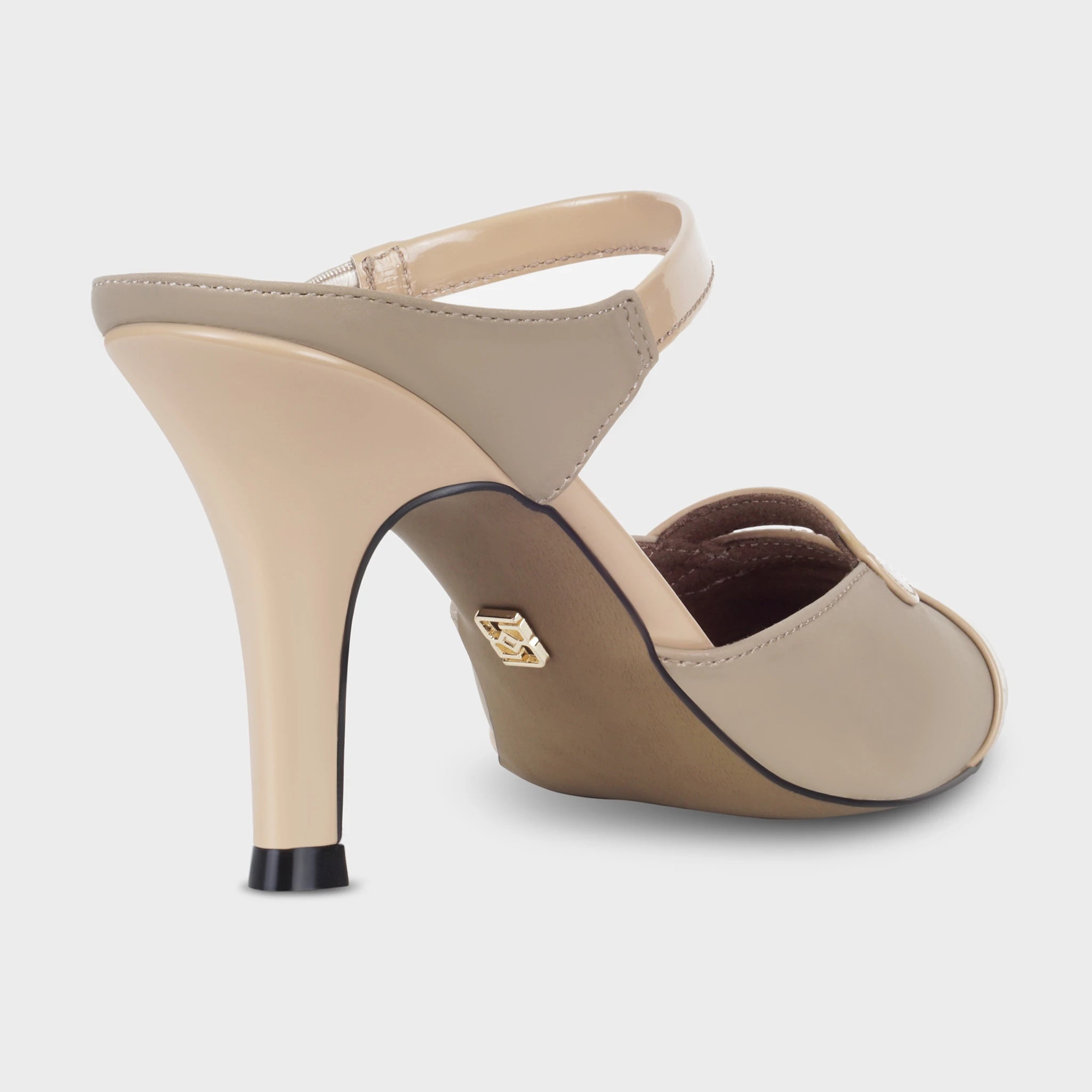 Rear view of Eloura taupe ankle strapped pump revealing the smooth heel blending from matte taupe upper into a polished nude finish, gold Glentè emblem on the outsole, and patent loop detail at the vamp - Glentè