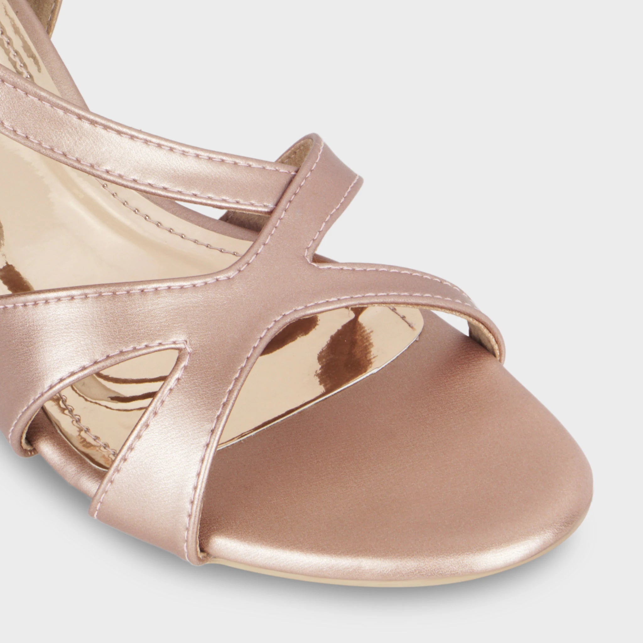 Close-up of the Orisea crossover toe straps showing precision stitching, teardrop cutout detailing, and luminous rose gold finish — Glentè