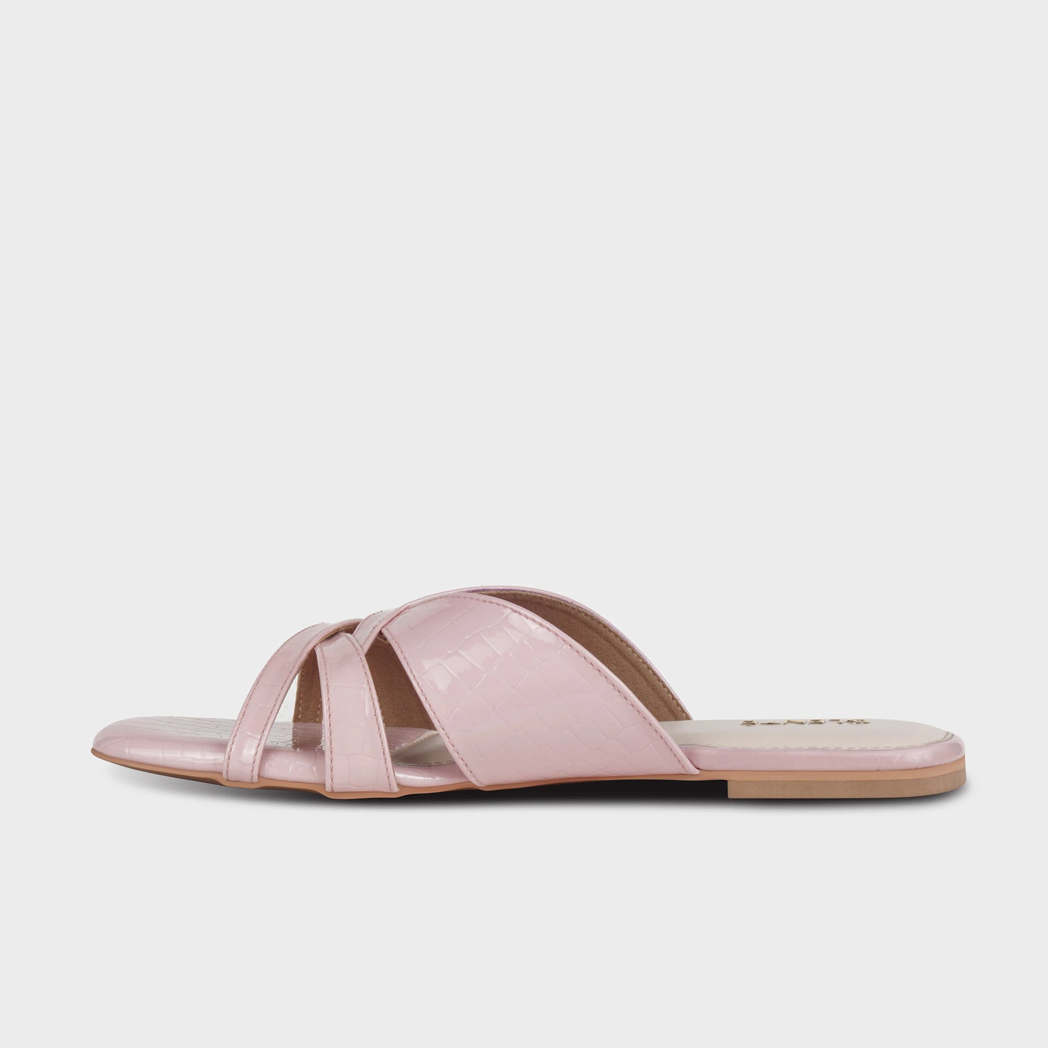 Inner side view of pink Seraya flat slides showing the layered crossover strap profile, croc-embossed texture, and slim tan outsole — Glentè