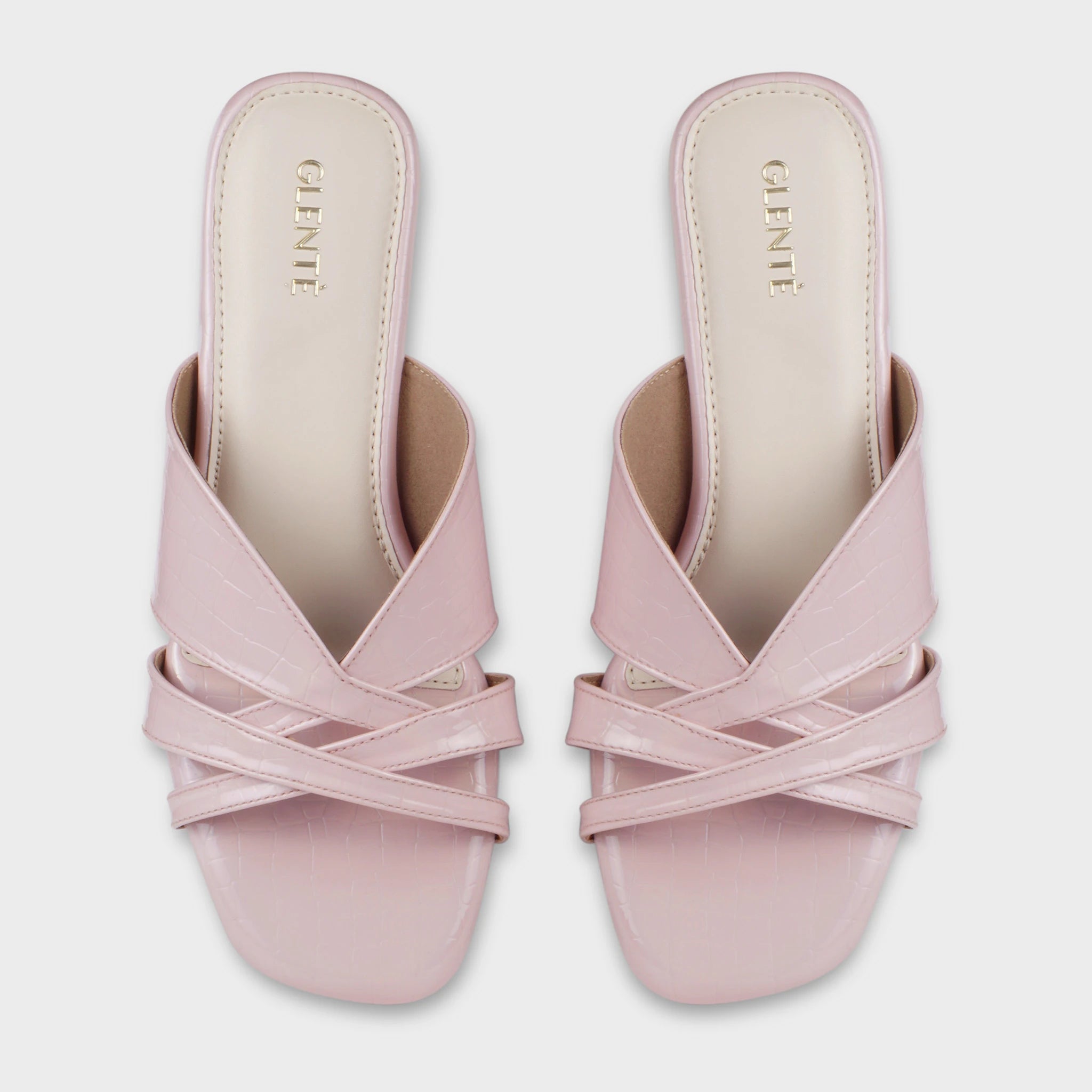 Top-down view of Seraya pink croc-embossed flat slides as a pair, showing the symmetrical multi-strap crossover design, square open toe, and gold Glentè branding on cream insoles