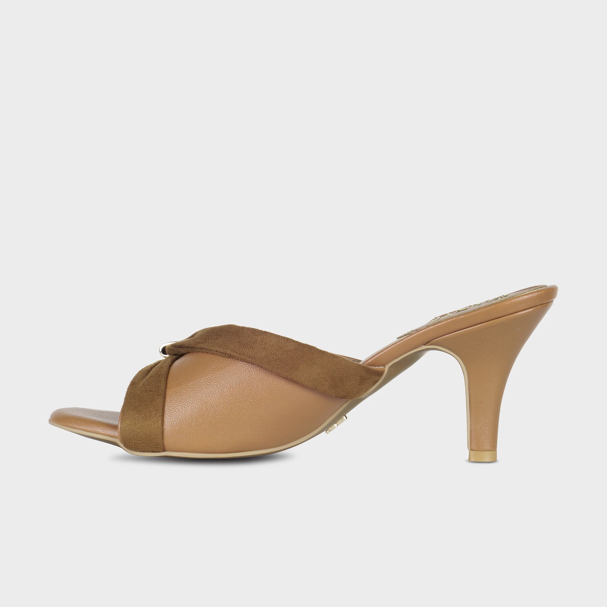 Inner side view of tan Solviane heeled mules showing the draped brown suede bow detail wrapping across the smooth leather upper and curved spool heel silhouette — Glentè