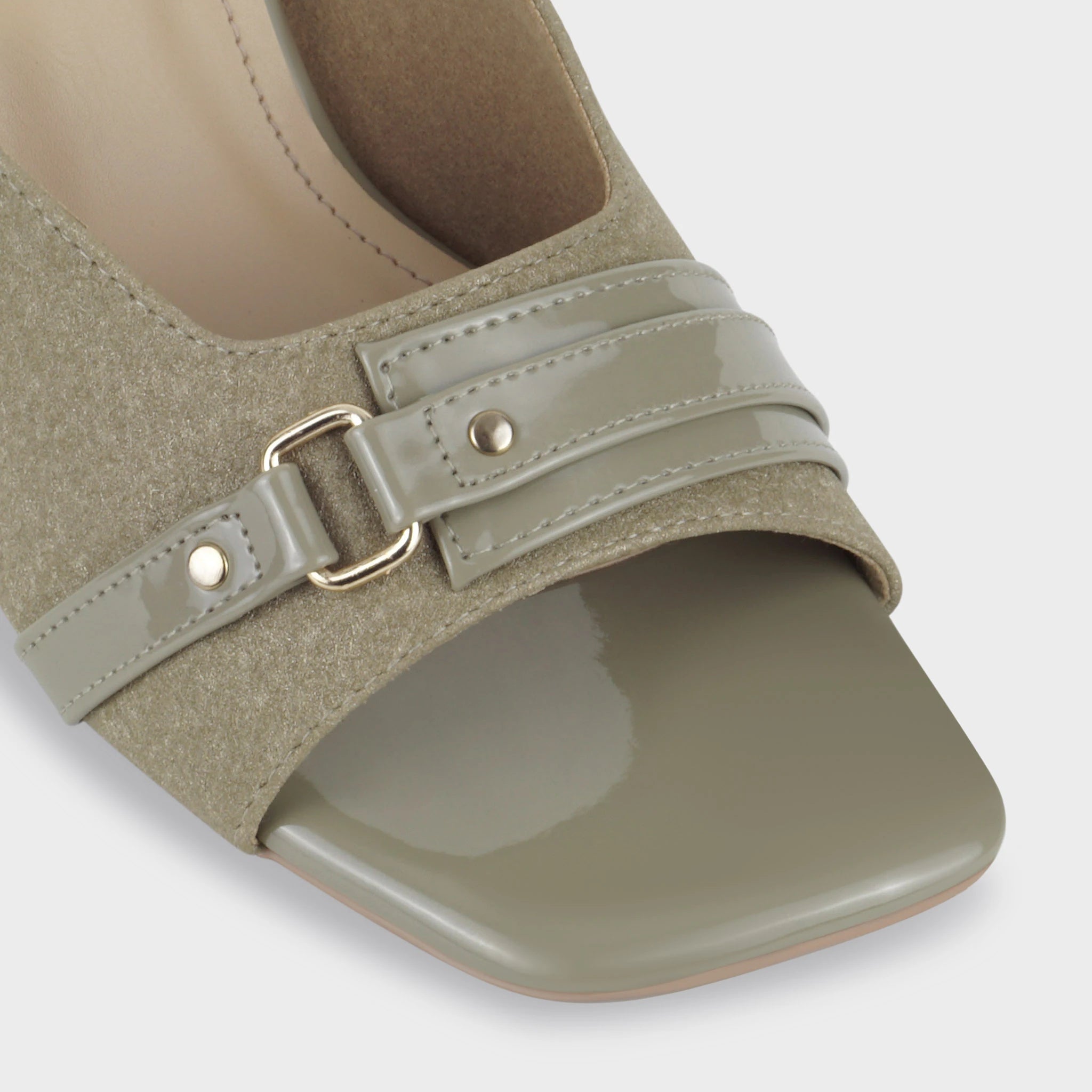 Glentè Viretta mule close-up - sage green suede vamp, patent harness strap with gold buckle and stud rivets, glossy square toe cap